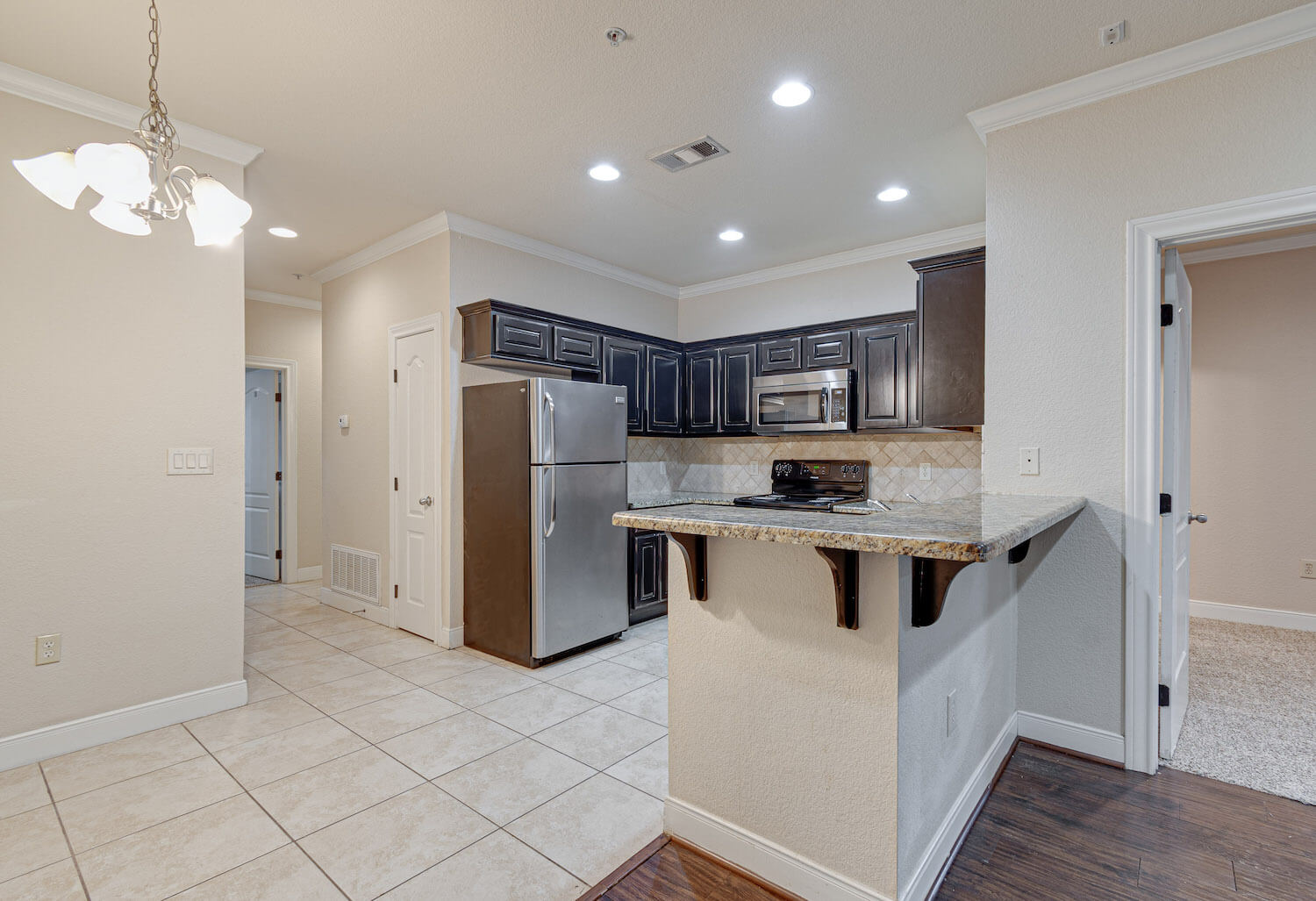 Brightly lit kitchen with marble counter that splits the living area and kitchen.