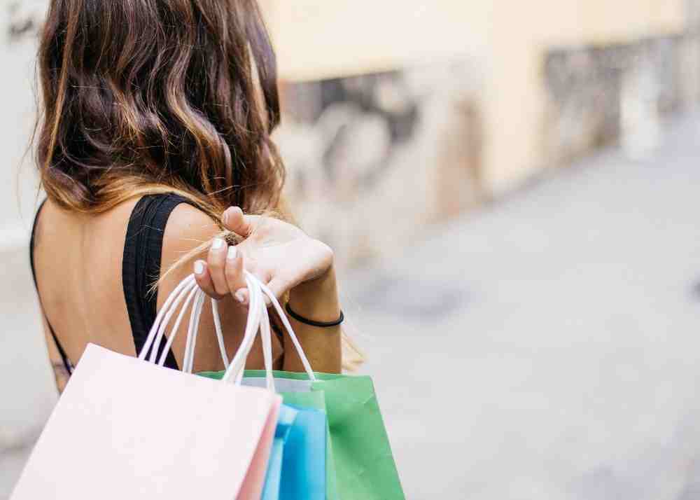 A woman holding shopping bags over her shoulder.